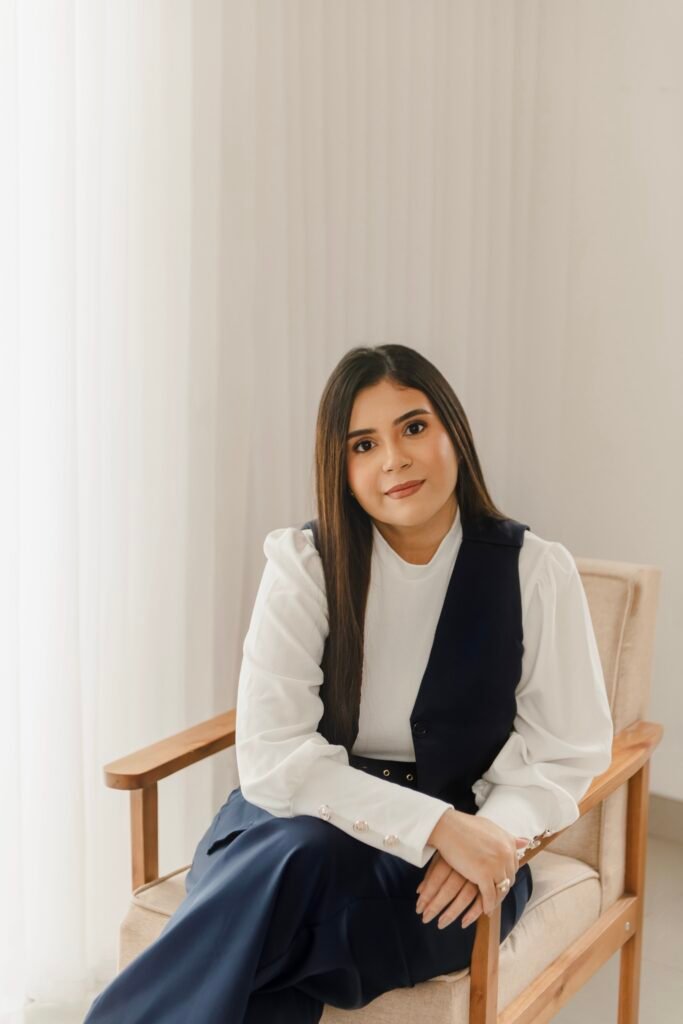 Profissional da saúde sentada, com olhar focado e postura segura, transmitindo acolhimento e atenção